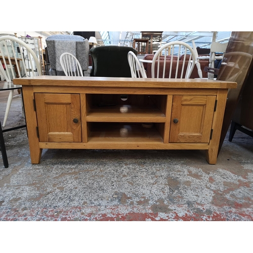 1053 - A modern solid oak TV stand - approx. 51cm high x 120cm wide x 44cm deep