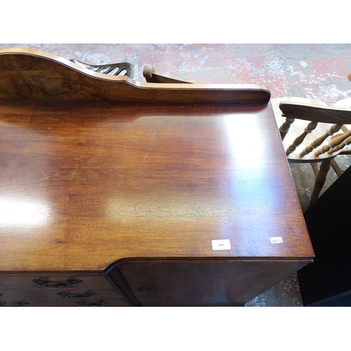 1062 - A mid 20th century walnut sideboard with four central drawers, two outer cupboard doors and cabriole... 