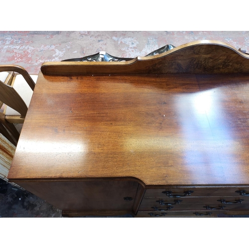 1062 - A mid 20th century walnut sideboard with four central drawers, two outer cupboard doors and cabriole... 