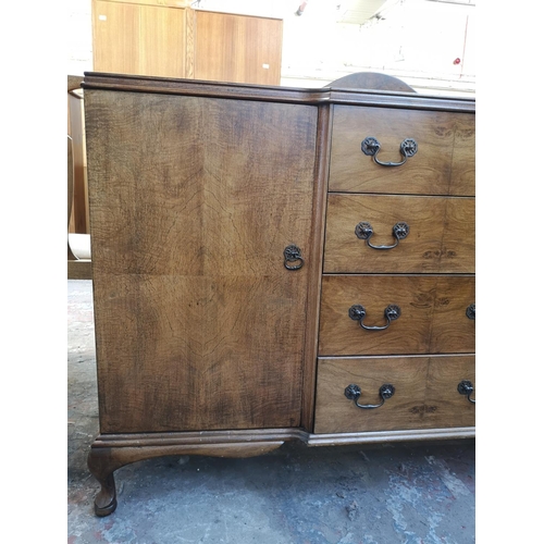 1062 - A mid 20th century walnut sideboard with four central drawers, two outer cupboard doors and cabriole... 