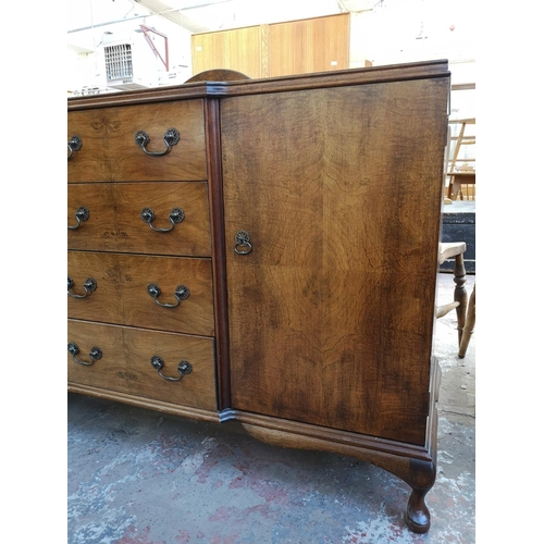 1062 - A mid 20th century walnut sideboard with four central drawers, two outer cupboard doors and cabriole... 