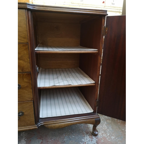 1062 - A mid 20th century walnut sideboard with four central drawers, two outer cupboard doors and cabriole... 