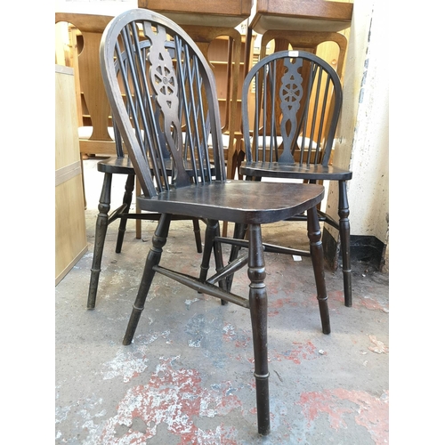 1064 - A set of four stained beech wheelback dining chairs