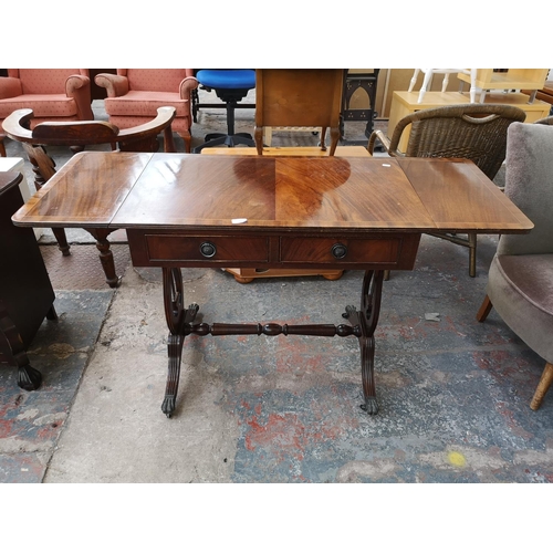 1082 - A Regency style mahogany drop leaf lyre end sofa table with two drawers