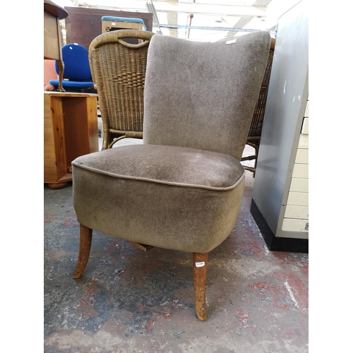 1084 - A mid 20th century green upholstered lounge chair on beech splayed supports