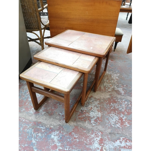 1087 - A mid 20th century teak and tiled top nest of three tables