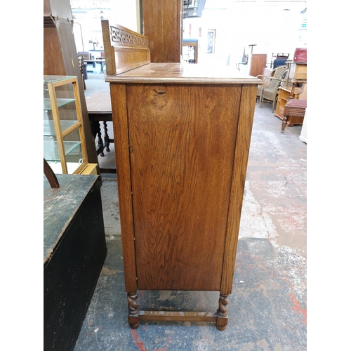 1106 - An early 20th century oak chest of two short over three long drawers with carved gallery back and ba... 