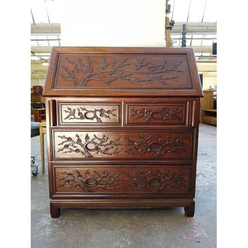 1117 - A Chinese rosewood bureau with two short drawers, two long drawers, fall front and bird and foliate ... 