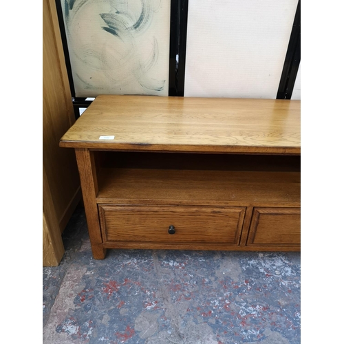 1131 - A modern oak TV stand with two lower drawers - approx. 47cm high x 110cm wide x 48cm deep