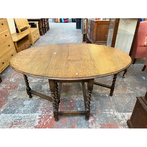 1122 - An early 20th century oak drop leaf gate leg dining table withy barley twist supports - approx. 72cm... 