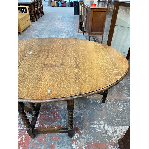 1122 - An early 20th century oak drop leaf gate leg dining table withy barley twist supports - approx. 72cm... 