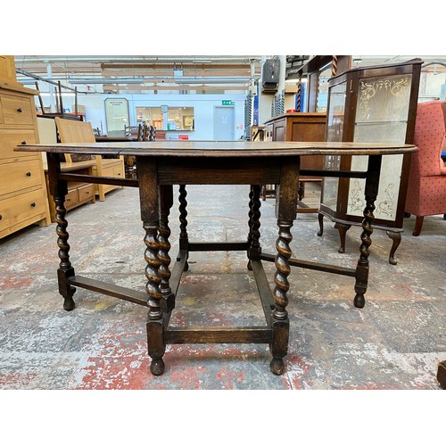 1122 - An early 20th century oak drop leaf gate leg dining table withy barley twist supports - approx. 72cm... 