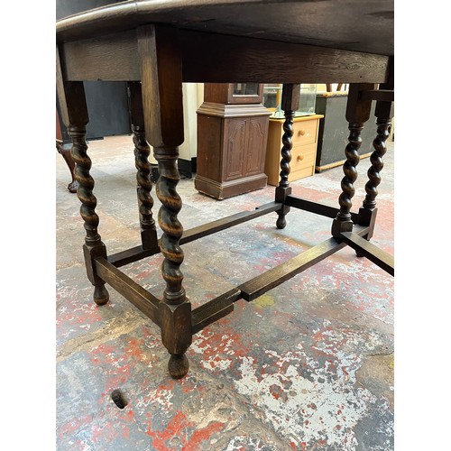 1122 - An early 20th century oak drop leaf gate leg dining table withy barley twist supports - approx. 72cm... 