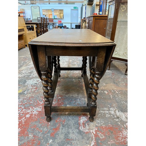 1122 - An early 20th century oak drop leaf gate leg dining table withy barley twist supports - approx. 72cm... 