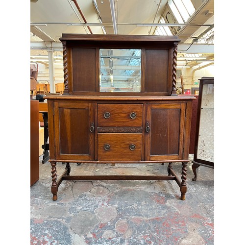 1120 - An early 20th century oak mirror back sideboard with barley twist design, two central drawers and tw... 