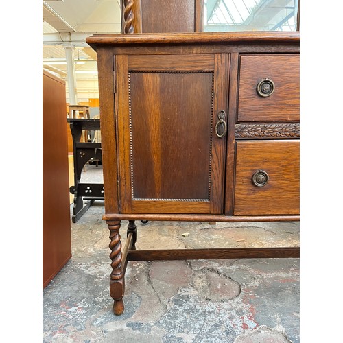 1120 - An early 20th century oak mirror back sideboard with barley twist design, two central drawers and tw... 