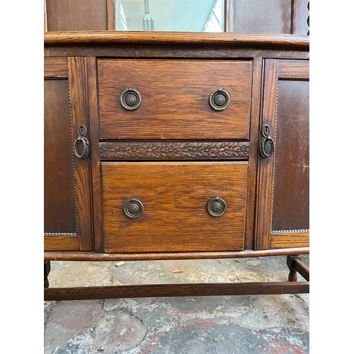 1120 - An early 20th century oak mirror back sideboard with barley twist design, two central drawers and tw... 