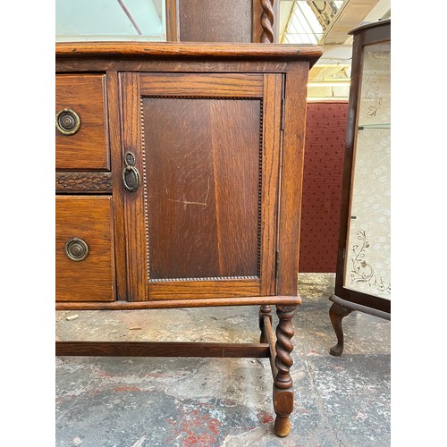 1120 - An early 20th century oak mirror back sideboard with barley twist design, two central drawers and tw... 