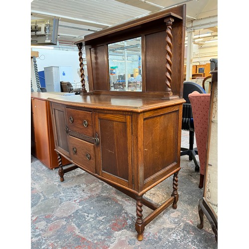 1120 - An early 20th century oak mirror back sideboard with barley twist design, two central drawers and tw... 