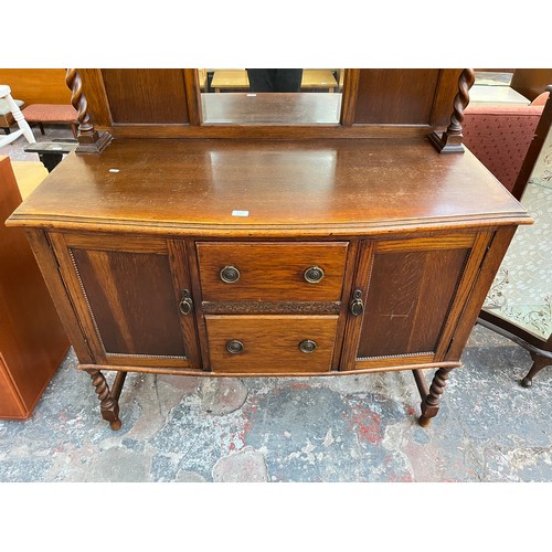 1120 - An early 20th century oak mirror back sideboard with barley twist design, two central drawers and tw... 