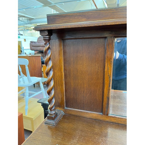 1120 - An early 20th century oak mirror back sideboard with barley twist design, two central drawers and tw... 