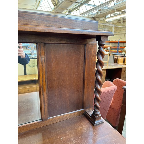 1120 - An early 20th century oak mirror back sideboard with barley twist design, two central drawers and tw... 