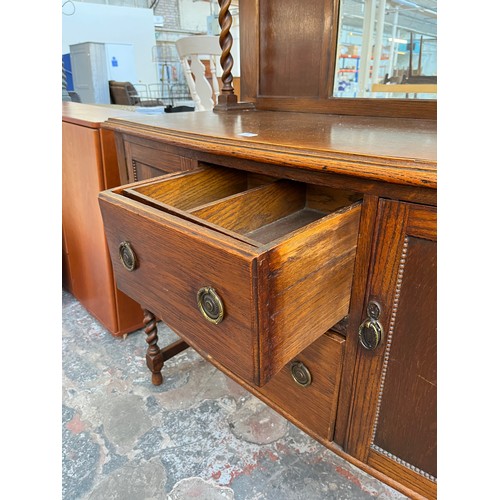 1120 - An early 20th century oak mirror back sideboard with barley twist design, two central drawers and tw... 