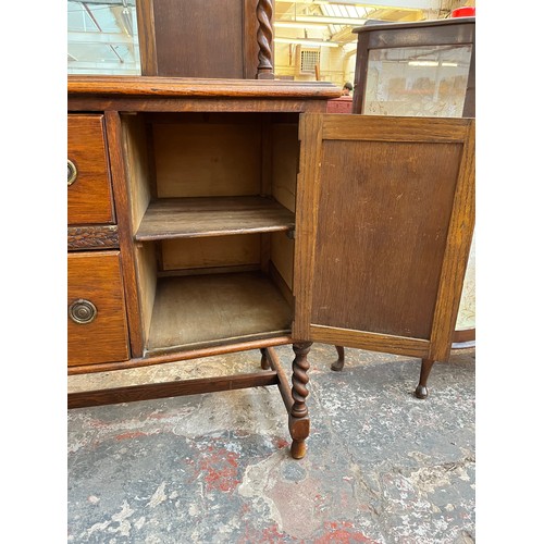 1120 - An early 20th century oak mirror back sideboard with barley twist design, two central drawers and tw... 