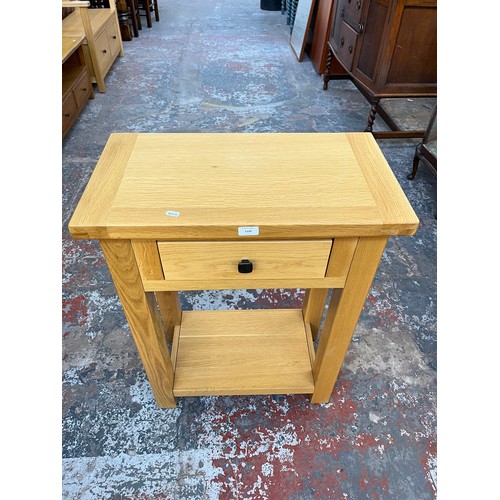 1129 - A modern solid oak single drawer two tier side table - approx. 85.5cm high x 65cm wide x 35cm deep