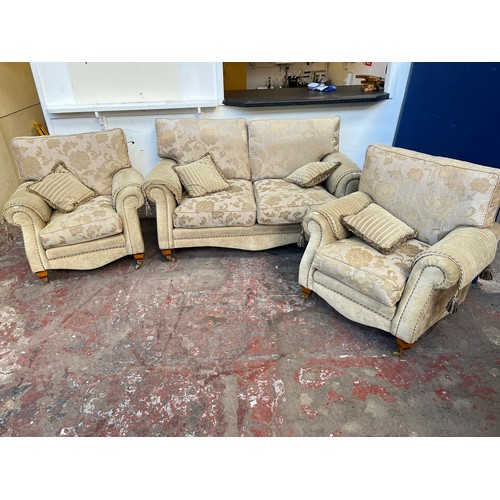 1023A - A Regency style beige floral upholstered three piece lounge suite comprising two seater sofa and two... 