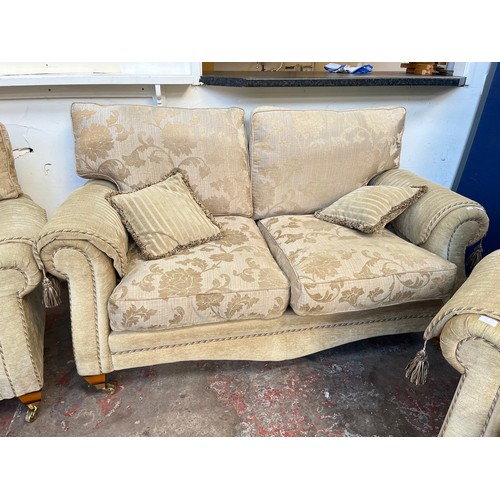 1023A - A Regency style beige floral upholstered three piece lounge suite comprising two seater sofa and two... 