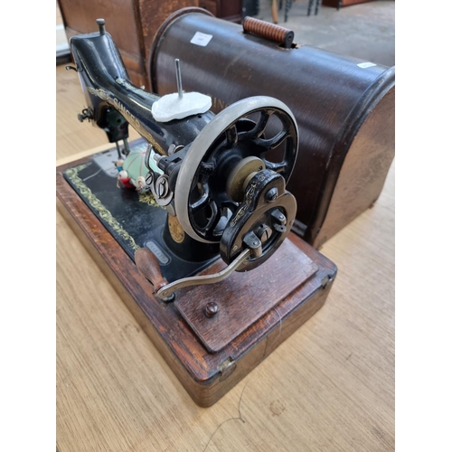 1547 - A cased c.1912 no.99 hand crank sewing machine with attachments - serial no. F2584120