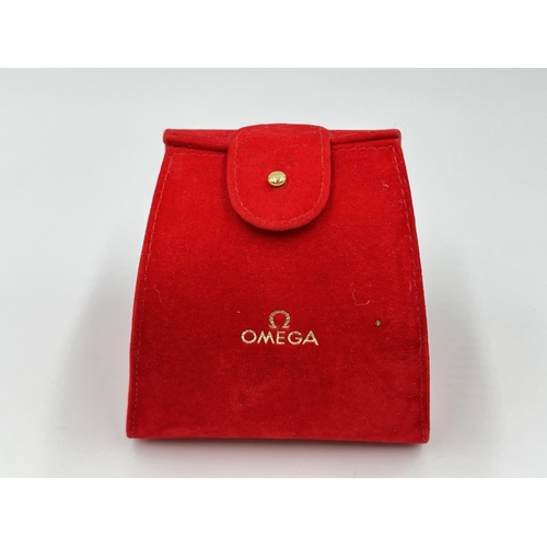 2184 - An original red velvet Omega watch pouch and cushion