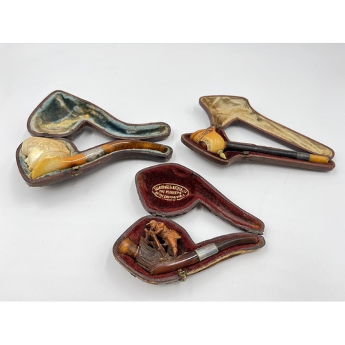 2261 - Three leather cased carved Meerschaum smoking pipes with hallmarked sterling silver collars and ambe... 