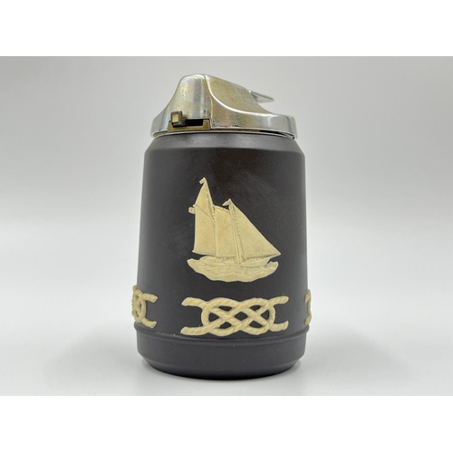 305 - Two Wedgwood table lighters, one black Jasperware with nautical scene and one black basalt