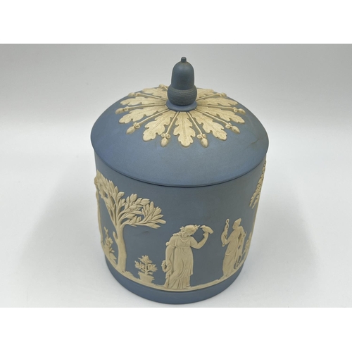 310 - Two pieces of Wedgwood pale blue Jasperware, one boxed biscuit barrel - approx. 17cm high and one pe... 