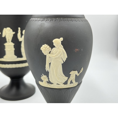 318 - Three Wedgwood black Jasperware vases, two 18.5cm and one 19cm