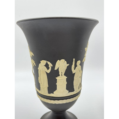 318 - Three Wedgwood black Jasperware vases, two 18.5cm and one 19cm