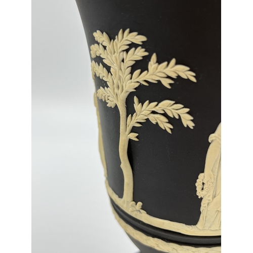 318 - Three Wedgwood black Jasperware vases, two 18.5cm and one 19cm