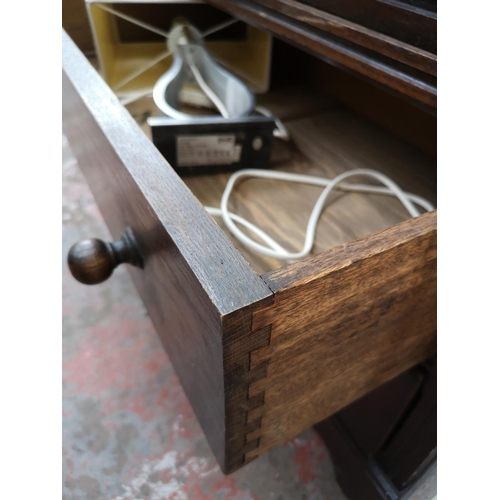 107 - An oak linen fold cabinet with two doors and two lower drawers