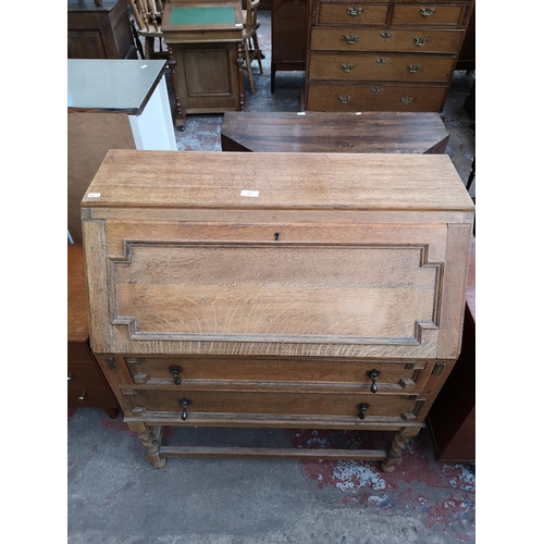 113 - An early 20th century oak geometric carved bureau with barley twist supports