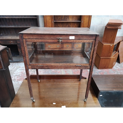 12 - An early 20th century oak and glass bijouterie table - approx. 70cm high x 59cm wide x 34cm deep