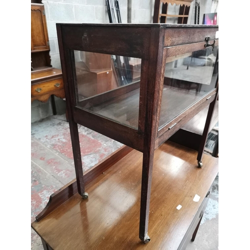 12 - An early 20th century oak and glass bijouterie table - approx. 70cm high x 59cm wide x 34cm deep