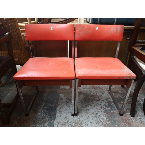 121 - A pair of 1970s orange vinyl and chrome plated dining chairs