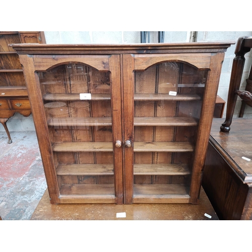 16 - A pine wall mountable display cabinet with two glazed doors - approx. 65cm high x 68cm wide x 13cm d... 