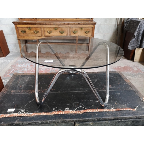 22 - A 1970s chrome plated and smoked glass topped circular side table - 35cm high x 61cm diameter