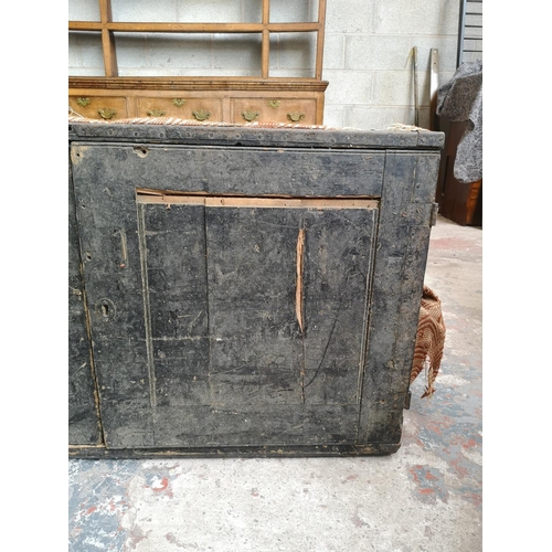 23 - An early 20th century pine travel trunk converted two door cabinet