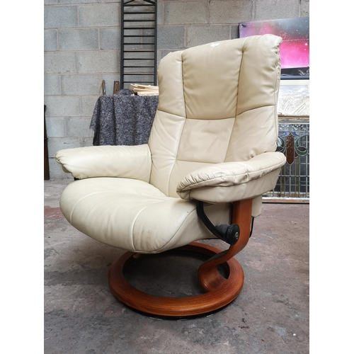 26 - An Ekornes Stressless cream leather swivel reclining armchair and footstool