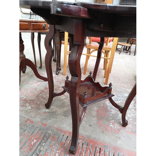 40 - An Edwardian mahogany quatrefoil folding two tier games table - approx. 69cm high x 45cm wide