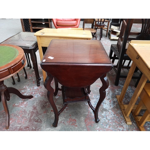 40 - An Edwardian mahogany quatrefoil folding two tier games table - approx. 69cm high x 45cm wide